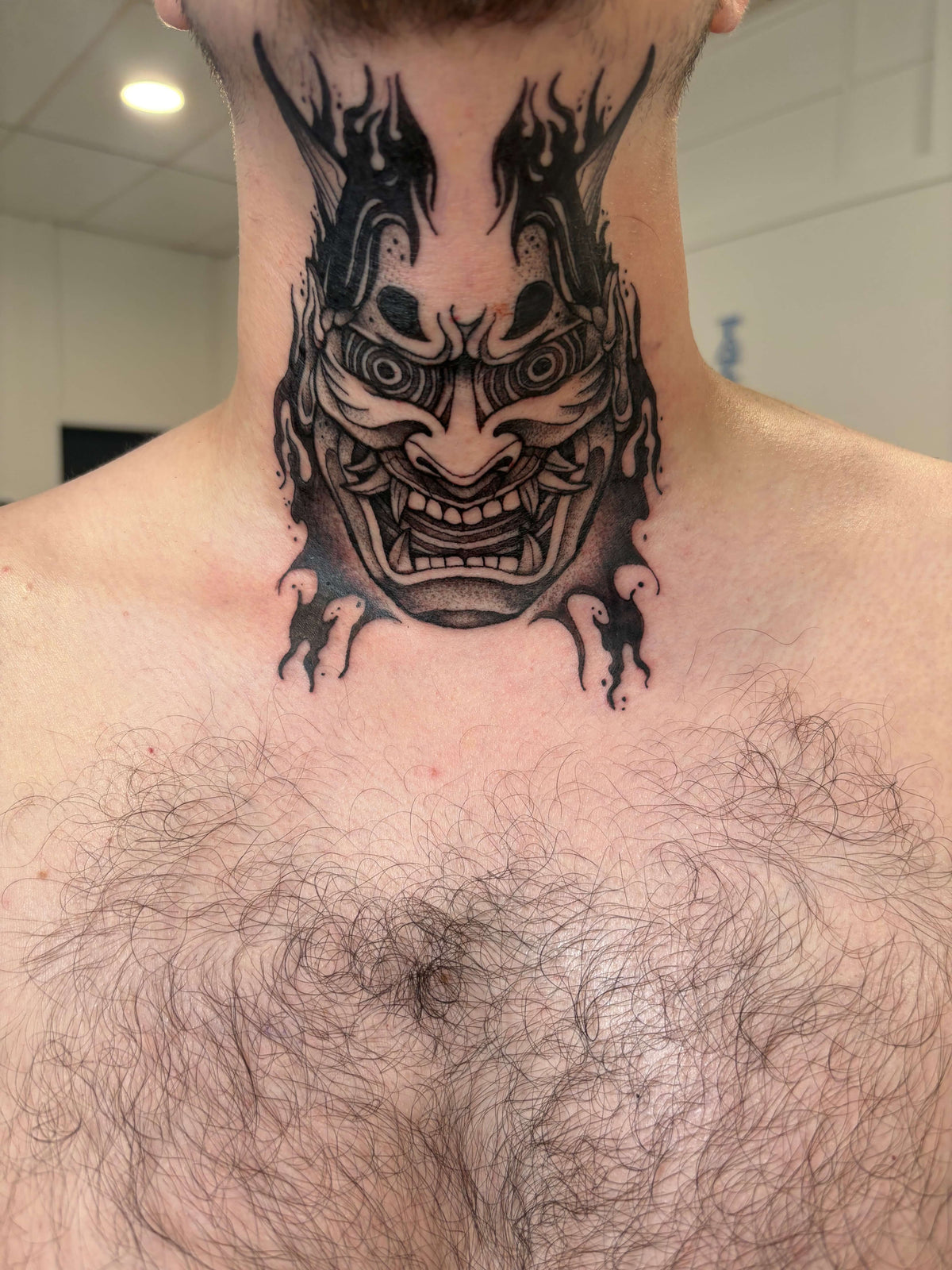 Japanese Hannya mask tattoo on the neck in a blackwork style
delboitattoos