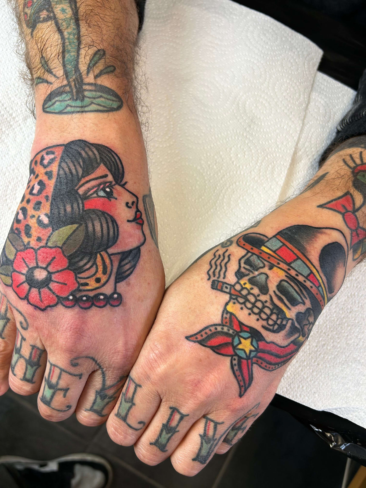 colour traditional hand tattoos of a woman's face and a skull
delboitattoos